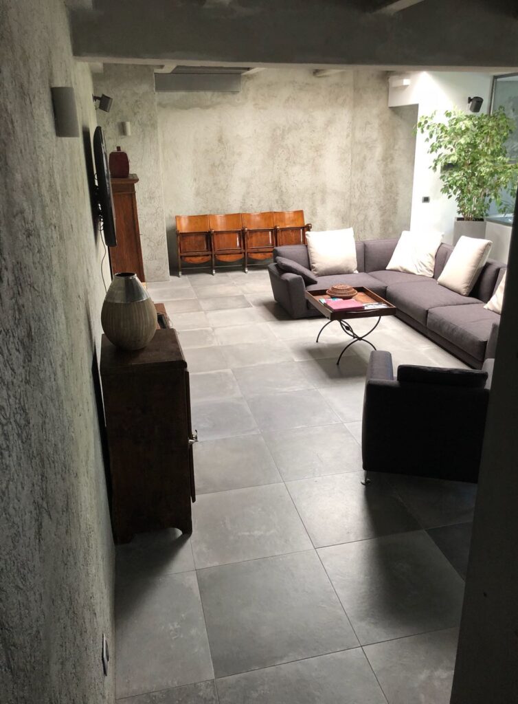 Loft di design moderno in stile minimal con cucina ad isola, vetrate, cemento lisciato e parquet a Milano per foto, video, eventi