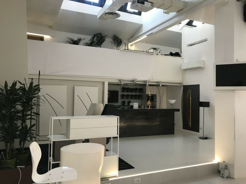 Spazio eventi industriale contemporaneo in stile minimal e total white con cucina ad isola a Milano per foto, video, eventi