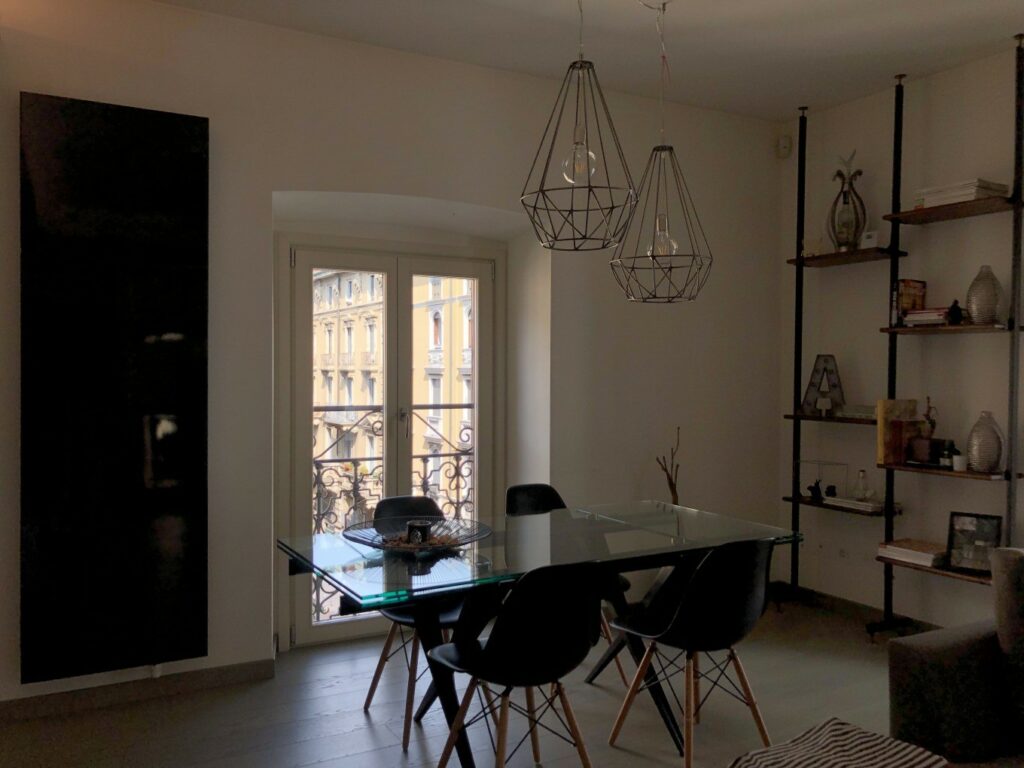 Appartamento di design minimal con cucina ad isola e parquet a Milano per foto, video, eventi
